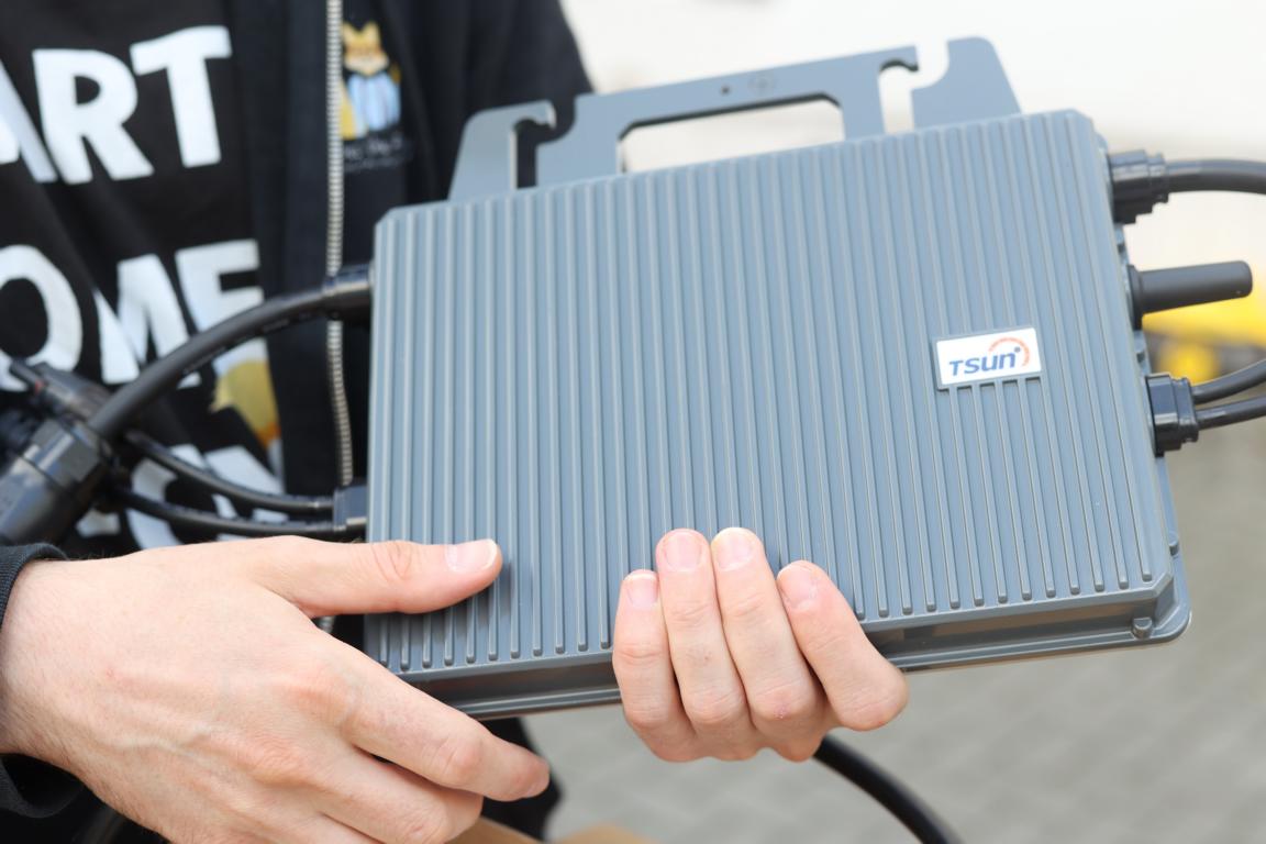 Ein TSUN Balkonkraftwerk Wechselrichter wird im Test in der Hand gehalten und präsentiert.